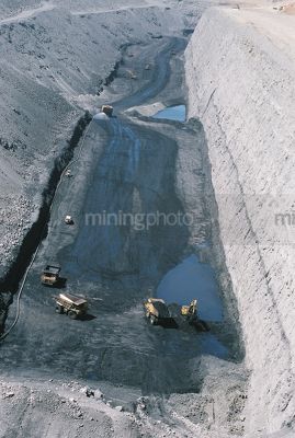 Vertical aerial photo of truck rotation in open cut coal mine.  Water cart in background spraying for dust suppression.  - Mining Photo Stock Library