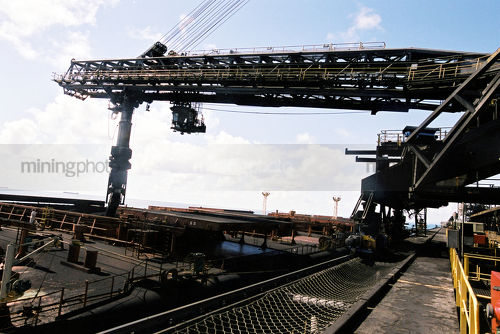 Close up photo of a ship loader loading coal at a terminal - Mining Photo Stock Library