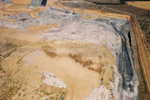 Aerial photo of overburden stock piling in open cut coal mine.  excavator and truck rotation and dragline in background. mine access haul roads adjacent. - Mining Photo Stock Library