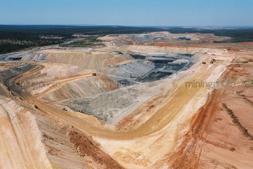 Great wide aerial photo of excavator loading overburden into haul trucks in open cut coal mine. - Mining Photo Stock Library
