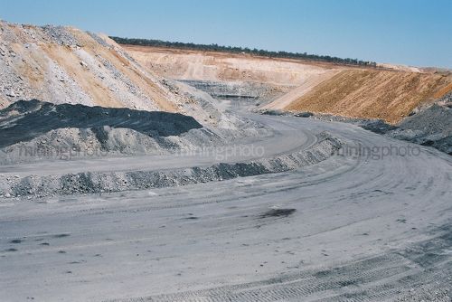 Close up of haul road leading down ramp into open cut coal mine pit. - Mining Photo Stock Library