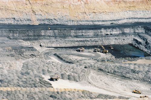 Wide aerial photo of excavator loading coal into haul trucks in open cut mine. - Mining Photo Stock Library