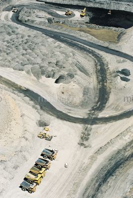 Vertical aerial photo of haul trucks at the go line in open cut coal mine.  excavator loading coal in background. - Mining Photo Stock Library