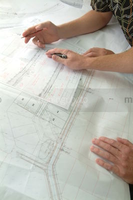 Closeup of hands above engineering property plans - Mining Photo Stock Library
