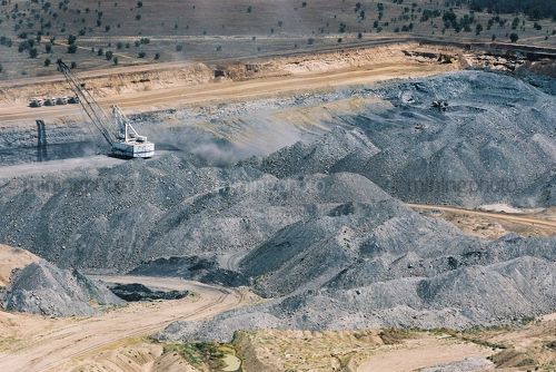 Dragline moving overburden at the top of an open cut coal mine.  rehabilitation in background. - Mining Photo Stock Library