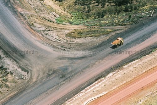 Loaded haul truck on haul access road in open cut coal mine.  aerial photo. - Mining Photo Stock Library