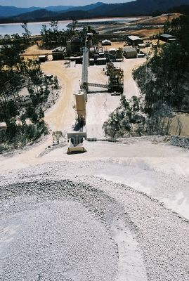 Gold mine processing plant with tailings dam in background.  stockpile in foreground.  shot from on top of the stockpile. - Mining Photo Stock Library