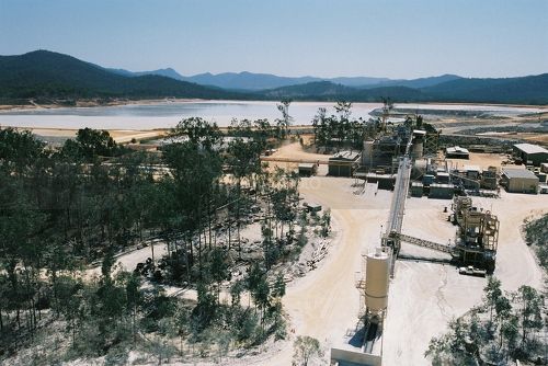 Gold mine processing plant with tailings dam in background.  stockpile in foreground.  shot from on top of the stockpile. - Mining Photo Stock Library