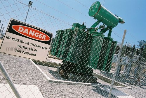 Power plant in mine site with razor barbed wire surround and safety sign. - Mining Photo Stock Library