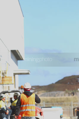 Mine construction worker in PPE walking next to work site.  vertical image. - Mining Photo Stock Library