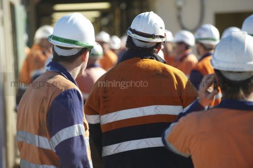 Mine workers in full PPE giving their attention during morning tool box talk. - Mining Photo Stock Library