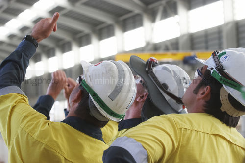 Mine construction workers in full PPE observing construction work inside building plant. - Mining Photo Stock Library