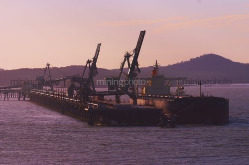 Aerial dusk afternoon photo of shiploader loading coal at wharf. - Mining Photo Stock Library
