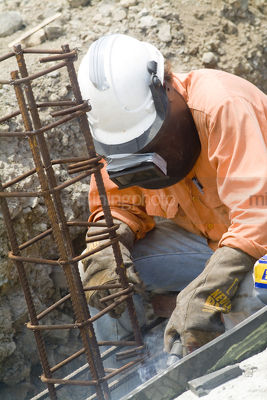 Male construction worker in full PPE welding concrete form work on a mine site. - Mining Photo Stock Library
