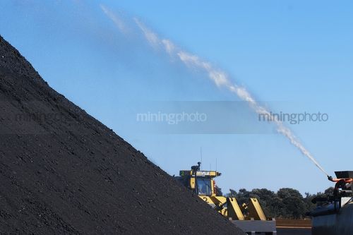 Water being sprayed onto coal stockpile to reduce dust suppression. - Mining Photo Stock Library