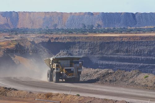 Loaded haul truck in open cut mine carrying overburden. - Mining Photo Stock Library