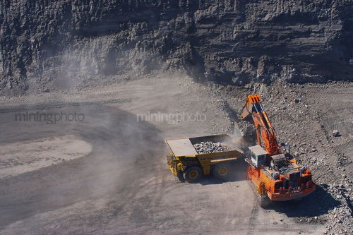 Aerial photo of an excavator working on a bench loading overburden in open cut coal mine - Mining Photo Stock Library