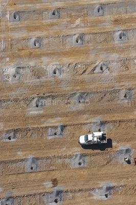 Close up aerial as a birds eye view of worker and ute loading blast holes at open cut mine site. - Mining Photo Stock Library