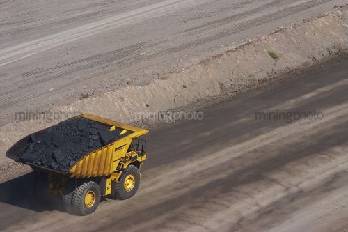 Loaded haul truck moving coal in open cut coal mine.  aerial shot. - Mining Photo Stock Library