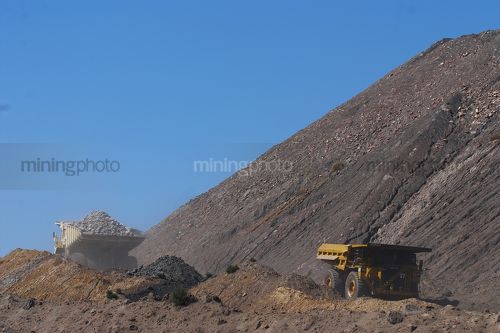 Two loaded haul trucks pass on haul road in open cut coal mine. Queensland Bowen Basin - Mining Photo Stock Library