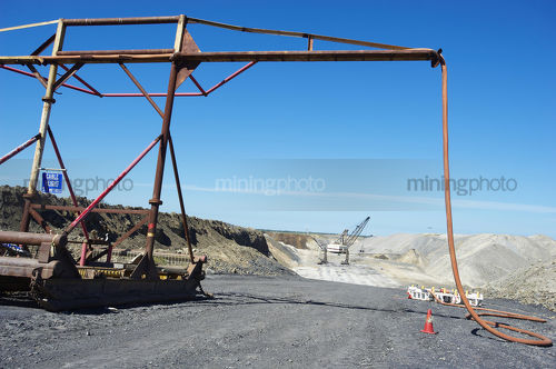 Dragline working in background removing overburden with drill rigs drilling blast holes and in foreground the dragline cable mast. open cut coal mine Bowen Basin Queensland.  - Mining Photo Stock Library