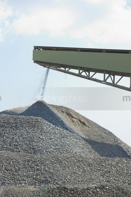 Vertical image of a conveyor loading product onto a stockpile - Mining Photo Stock Library