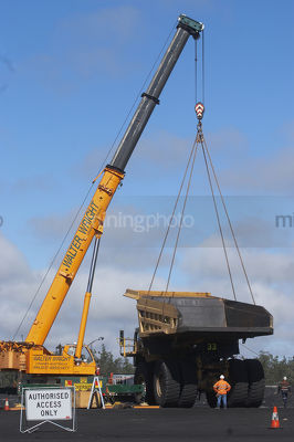 Large crane lifting the tray off a haul truck in a workshop area at a mine site. workers in full PPE observing. - Mining Photo Stock Library