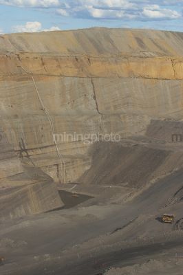 Vertical photo of open cut coal mine.  great photo of high walls with a haul truck for scale to show the depth of the pit. - Mining Photo Stock Library