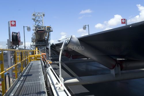 Shiploader and coal conveyor at coal terminal.  fire hose in foreground. - Mining Photo Stock Library