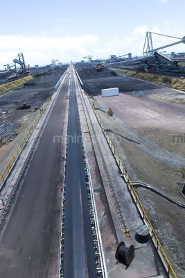Vertical photo of access road at coal terminal.  reclaimers working in the background. - Mining Photo Stock Library