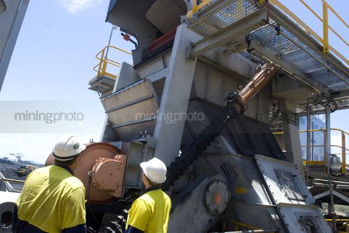Two 2 mine workers in full PPE inspecting a coal hopper at a mine site. - Mining Photo Stock Library