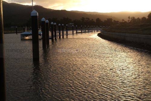 Sunset over water in canal waterfront property subdvision - Mining Photo Stock Library