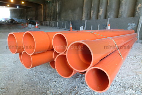 Pile of storm water pipes in road tunnel during construction - Mining Photo Stock Library