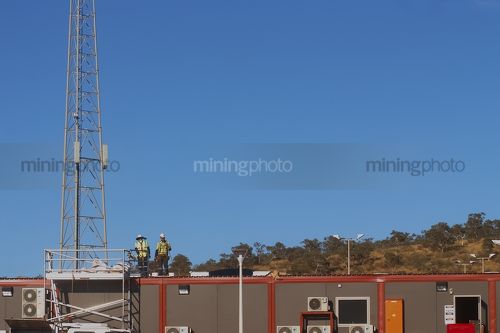 Two mine construction workers installing roof on mining camp accomodation - Mining Photo Stock Library