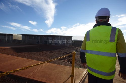 Mine worker in full PPE walking through the mining camp and accomodation - Mining Photo Stock Library
