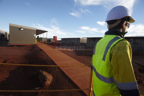 Mine worker in full PPE walking through the mining camp and accomodation - Mining Photo Stock Library
