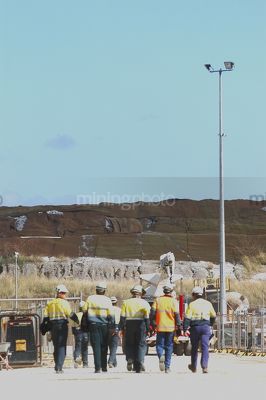 Group of mine workers in full PPE walking in shows teamwork.  vertical portrait photo. - Mining Photo Stock Library