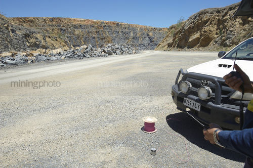 Mine site quarry blast about to happen.  shot firer talking on radio confirming the firing. - Mining Photo Stock Library