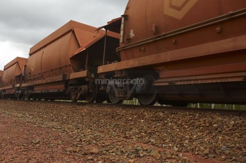 Close up photo of rail train  carriages moving at mine site. - Mining Photo Stock Library