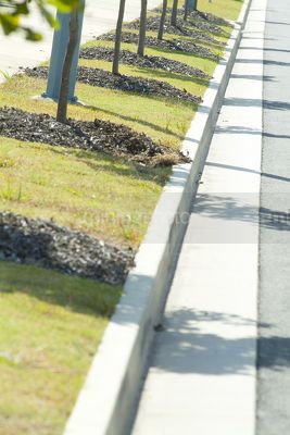 Generic landscaped footpath with gutter in property subdivision.  shot from road level. - Mining Photo Stock Library