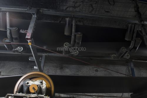 Close up photo of underground coal conveyor working.  - Mining Photo Stock Library