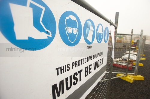 Safety signage at mine site gate.  temporary fencing surrounding site as well.  can also apply to construction site. - Mining Photo Stock Library