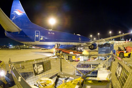 Freight being loaded onto cargo plane at airport. shot at night. - Mining Photo Stock Library