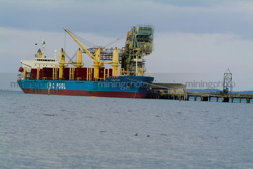 Berthed ship being loaded from wharf. - Mining Photo Stock Library