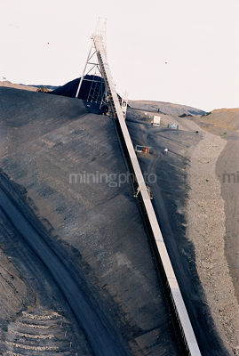 Underground conveyor emptying coal to outside stockpile vertical image - Mining Photo Stock Library