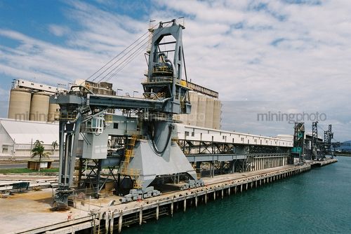Long shipping wharf with silos and ship loaders - Mining Photo Stock Library