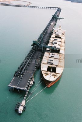 Great aerial image of ship being loaded by conveyor with coal at a terminal - Mining Photo Stock Library