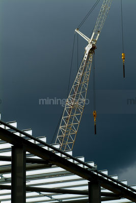 Crane working above commercial steel building - Mining Photo Stock Library