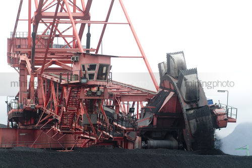 Front on image of coal reclaimer working  at port facility - Mining Photo Stock Library