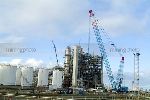 Crane lifting steel framework into place on large silo plant - Mining Photo Stock Library